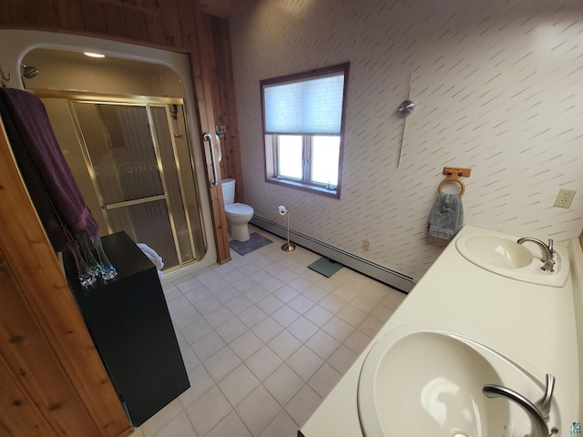 bathroom featuring a stall shower, a sink, toilet, and double vanity