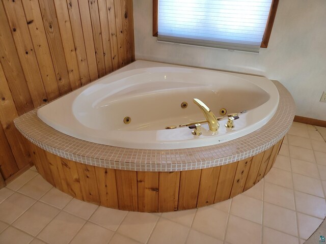 bathroom featuring tile patterned flooring and a tub with jets