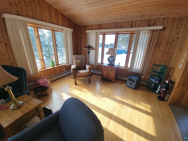 sitting room with light wood-style floors, a wealth of natural light, vaulted ceiling, and a baseboard radiator