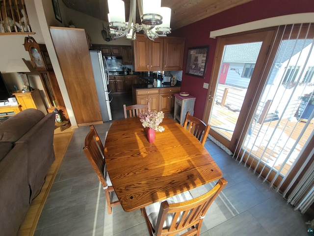 dining space featuring a notable chandelier and vaulted ceiling