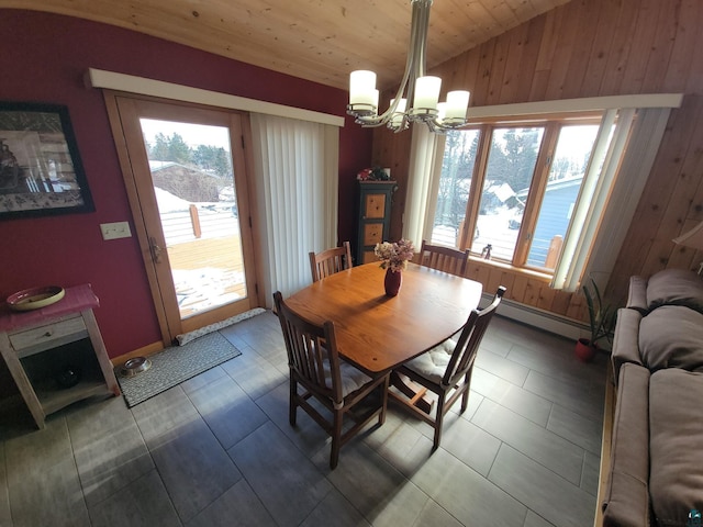 dining space with a chandelier, a wealth of natural light, vaulted ceiling, and a baseboard radiator