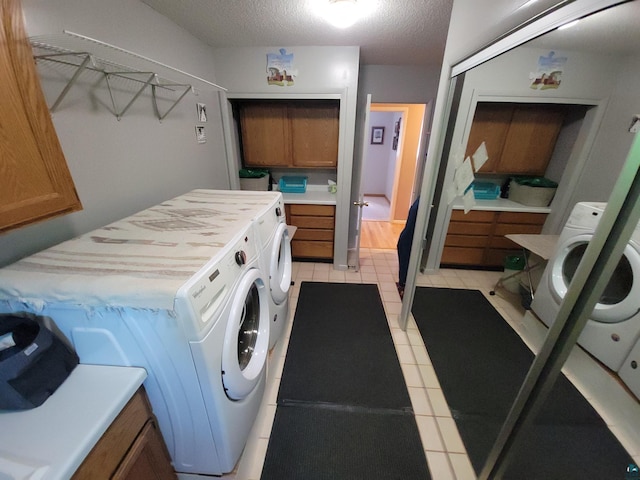 washroom featuring laundry area, a textured ceiling, and washing machine and clothes dryer