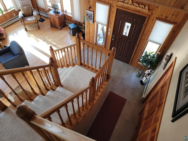 foyer featuring dark wood-style flooring, wood walls, and baseboard heating