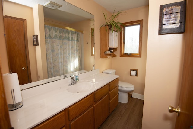 full bathroom featuring baseboards, visible vents, toilet, wood finished floors, and vanity