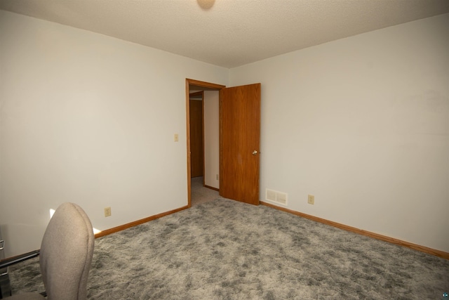 interior space with carpet, visible vents, a textured ceiling, and baseboards