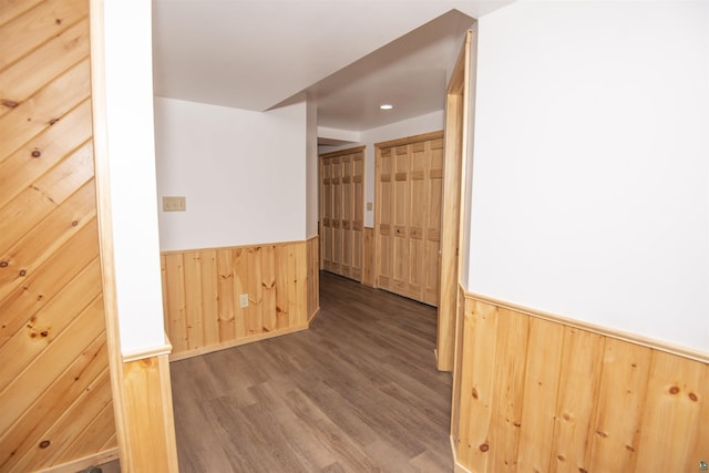 hallway with a wainscoted wall, wood finished floors, and wooden walls