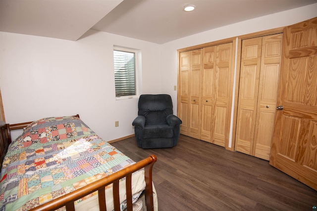 bedroom with dark wood-type flooring, recessed lighting, two closets, and baseboards