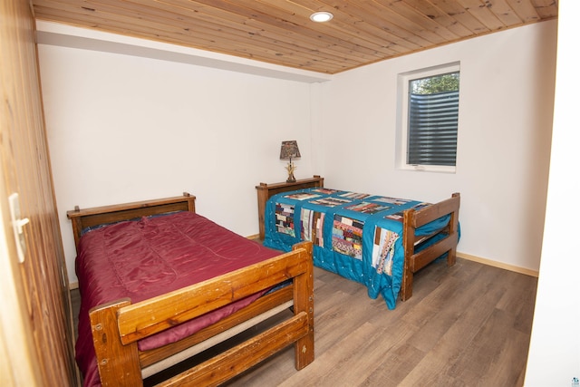 bedroom featuring wooden ceiling, baseboards, and wood finished floors