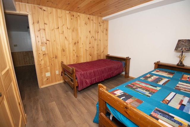 bedroom featuring wood ceiling, wooden walls, and dark wood-type flooring