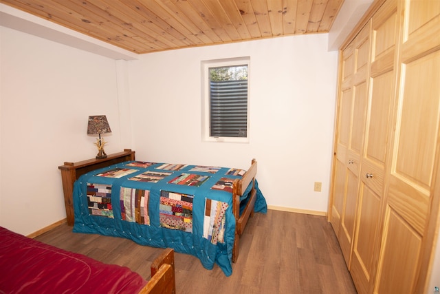 bedroom featuring wood ceiling, baseboards, and wood finished floors