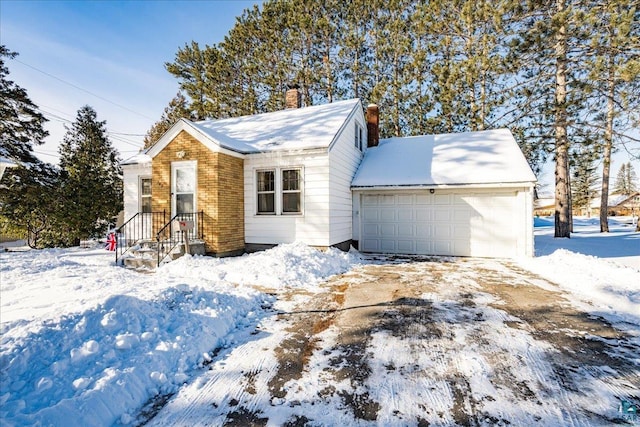 view of front of home featuring a garage, a chimney, and brick siding