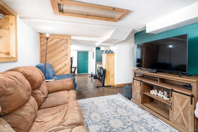 living area featuring baseboards, concrete flooring, and a textured ceiling