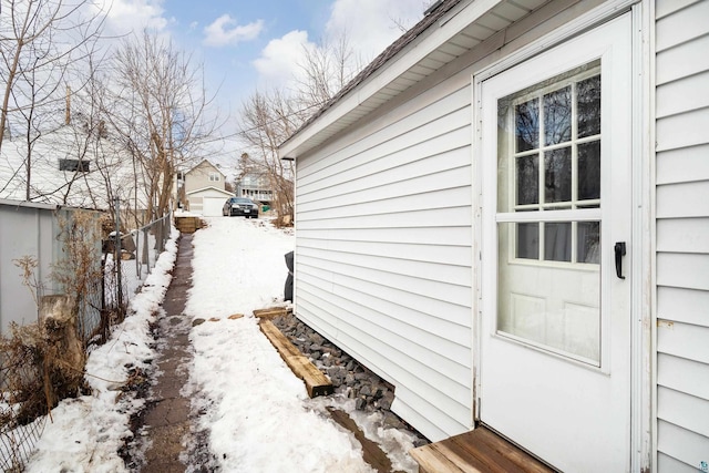 snow covered property with fence