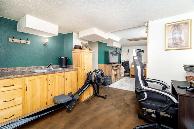 exercise room featuring a sink, wet bar, and a textured ceiling