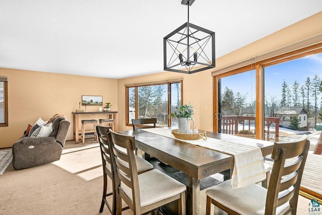 dining room featuring a chandelier and light carpet