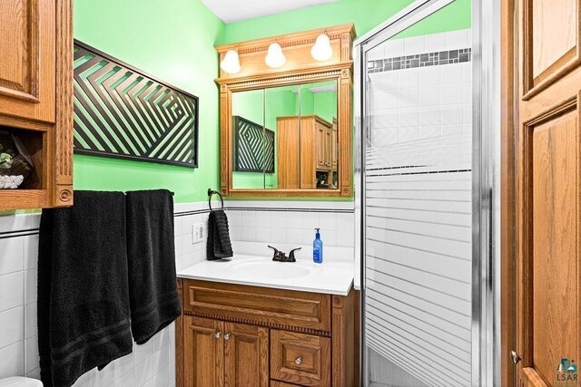 bathroom featuring decorative backsplash, vanity, and tile walls