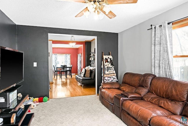 living room with carpet, wood finished floors, and a ceiling fan