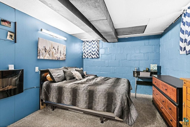 carpeted bedroom with concrete block wall