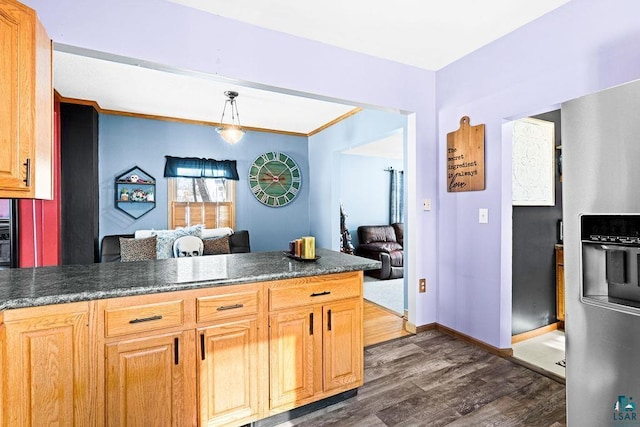 kitchen featuring decorative light fixtures, dark countertops, dark wood-type flooring, a peninsula, and baseboards