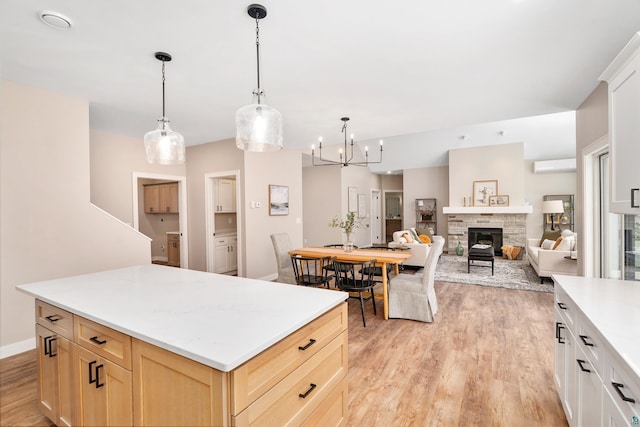 kitchen with light brown cabinetry, light wood-style flooring, light countertops, and a wall mounted AC