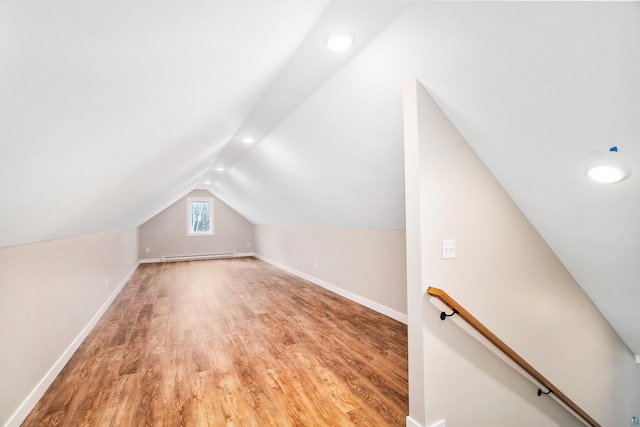 bonus room featuring baseboards, lofted ceiling, a baseboard radiator, light wood-type flooring, and recessed lighting