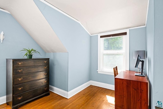 office space featuring lofted ceiling, baseboards, and wood finished floors