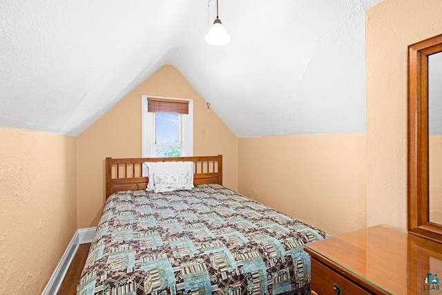 bedroom featuring vaulted ceiling and baseboards