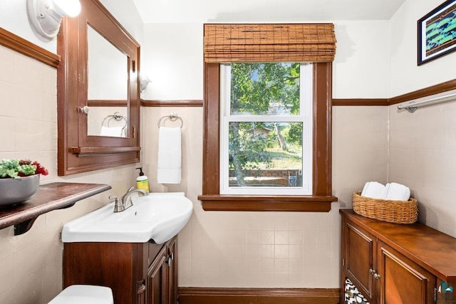 half bathroom featuring tile walls and vanity