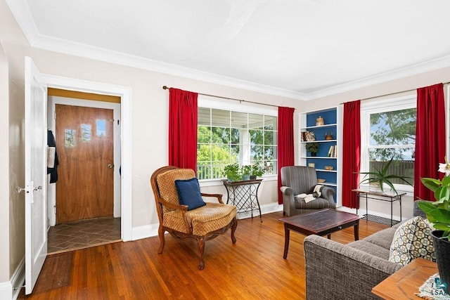 sitting room featuring baseboards, wood finished floors, and crown molding