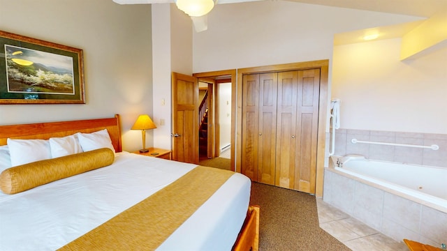 bedroom with a closet, vaulted ceiling, and light tile patterned floors