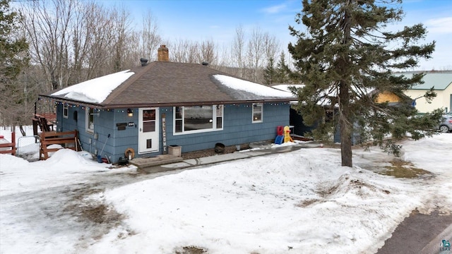 view of front of house featuring a shingled roof and a chimney