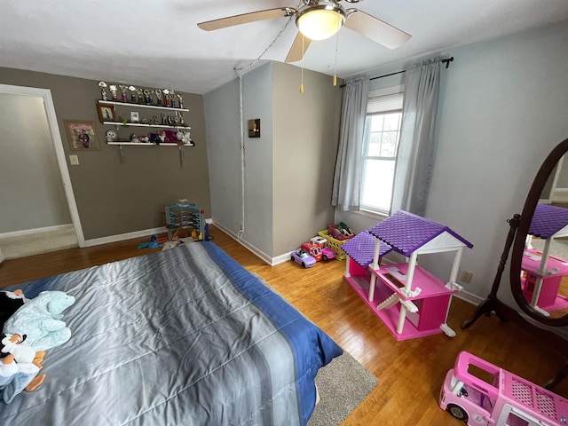 bedroom with ceiling fan, baseboards, and wood finished floors