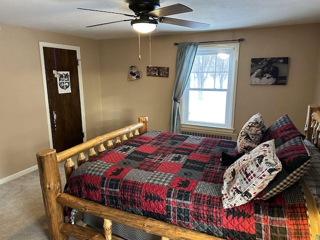 carpeted bedroom with a ceiling fan, baseboards, and radiator heating unit