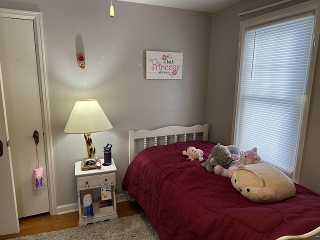 bedroom featuring multiple windows and wood finished floors