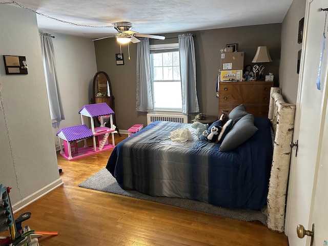 bedroom with a ceiling fan, baseboards, and wood finished floors