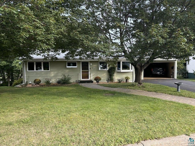 ranch-style house with driveway, an attached carport, and a front yard