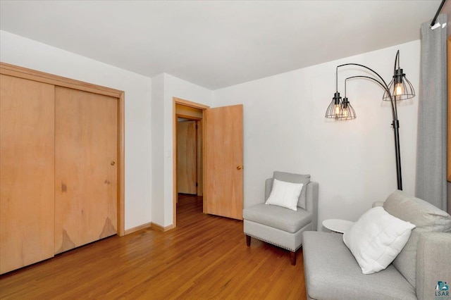 living area with light wood-type flooring and baseboards