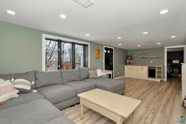 living area with recessed lighting, visible vents, and light wood-style flooring