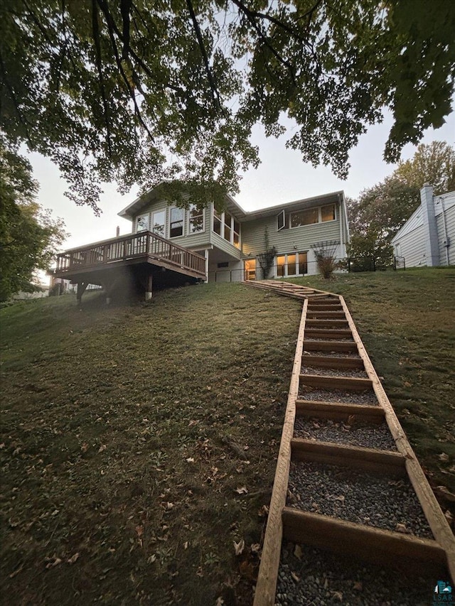 rear view of house featuring a deck and stairs