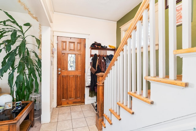 foyer entrance with stairs, ornamental molding, and light tile patterned flooring