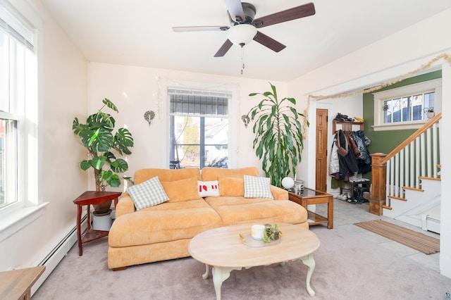 living area with a baseboard heating unit, stairway, plenty of natural light, and carpet flooring