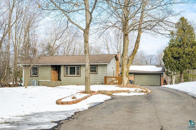 ranch-style home with a garage, central AC, aphalt driveway, and a chimney