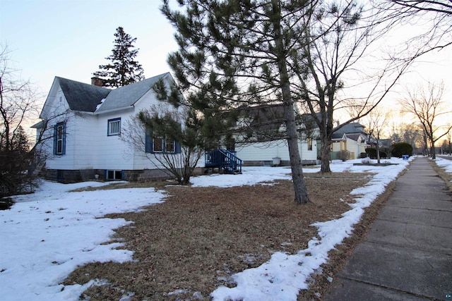 snow covered property with a chimney