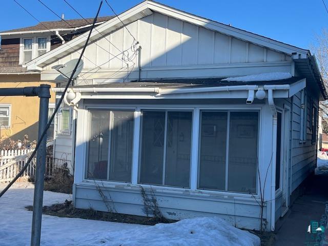 exterior space with board and batten siding and fence