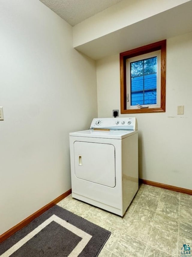 laundry area with washer / clothes dryer, a textured ceiling, baseboards, and laundry area