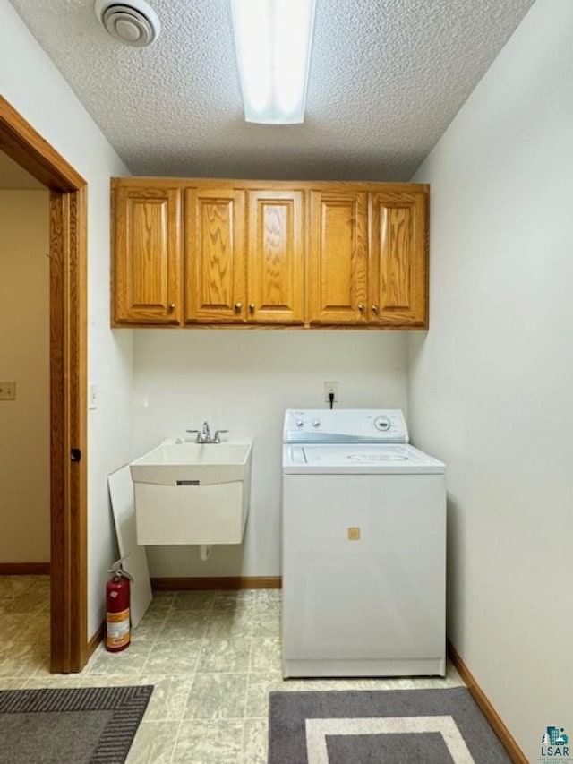 washroom with visible vents, cabinet space, washer / dryer, and baseboards