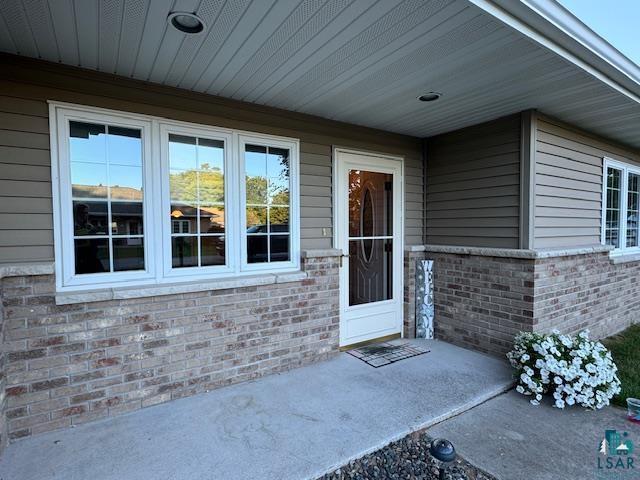 view of exterior entry featuring brick siding