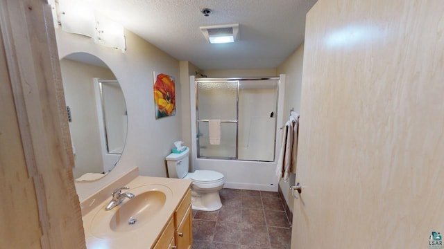 bathroom with a textured ceiling, tile patterned flooring, toilet, vanity, and combined bath / shower with glass door