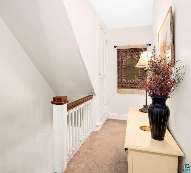 hall with light colored carpet and baseboards