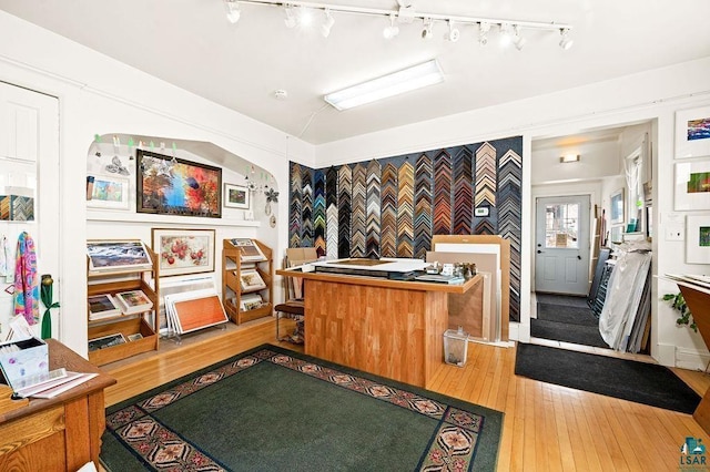 interior space featuring arched walkways, an accent wall, and hardwood / wood-style flooring